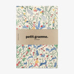 Notebook with a colorful animal pattern and 'petit gramme' branding on a white background