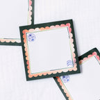 Decorative sticky notes with scalloped edges and postage stamp designs on a white background