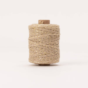 Spool of beige thread on a white background