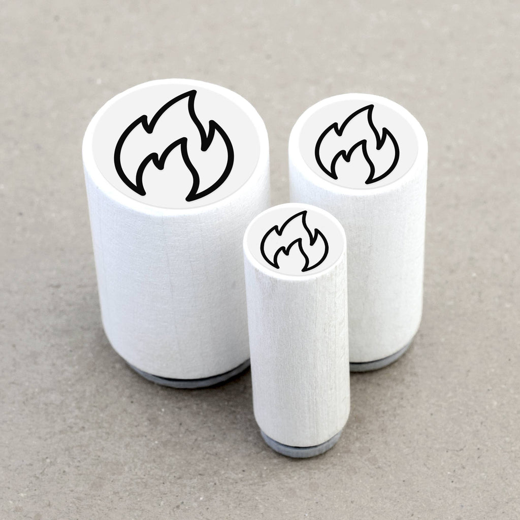 Three white rubber stamps with flame designs on a gray background