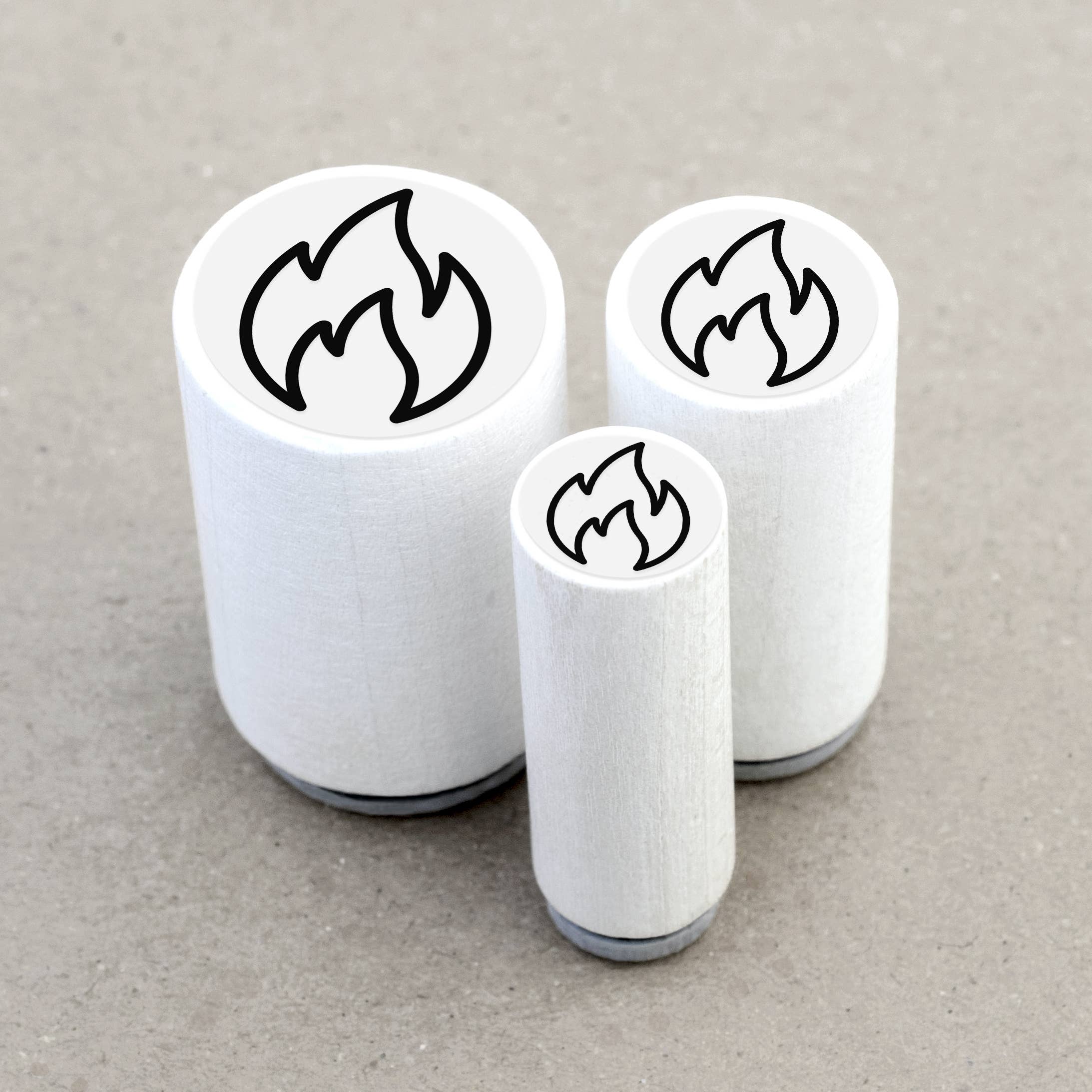 Three white rubber stamps with flame designs on a gray background