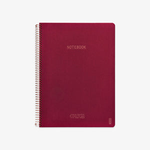 Red notebook with spiral binding on a white background