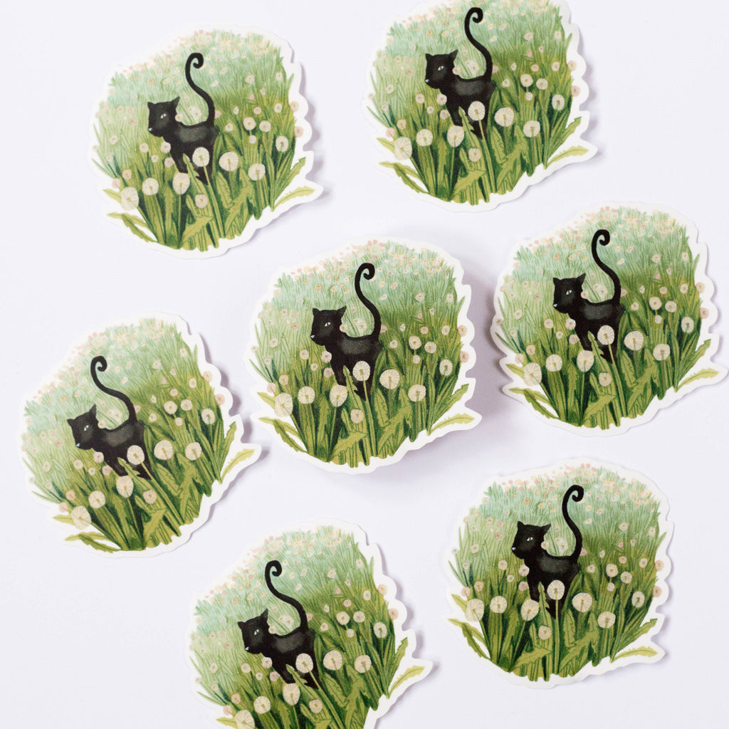 Set of eight stickers with black cats in grass and flowers on a white background