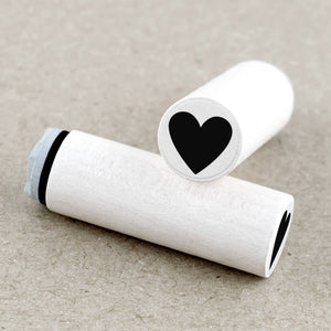 Two wooden rubber stamps with black heart symbols on a beige background