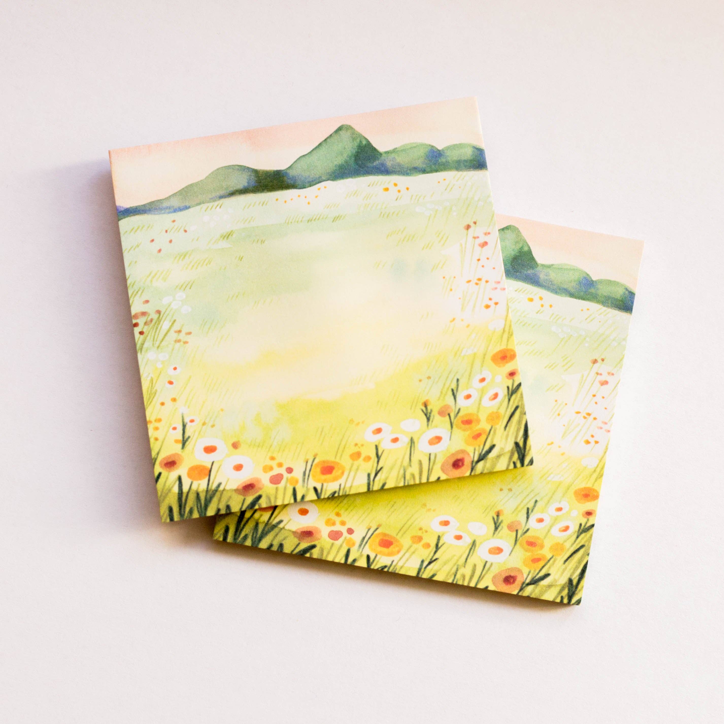 Two sticky notes with a floral landscape design on a light background
