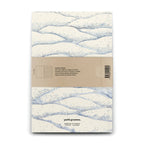 Notebook with wave pattern and Petit Gramme branding on a white background