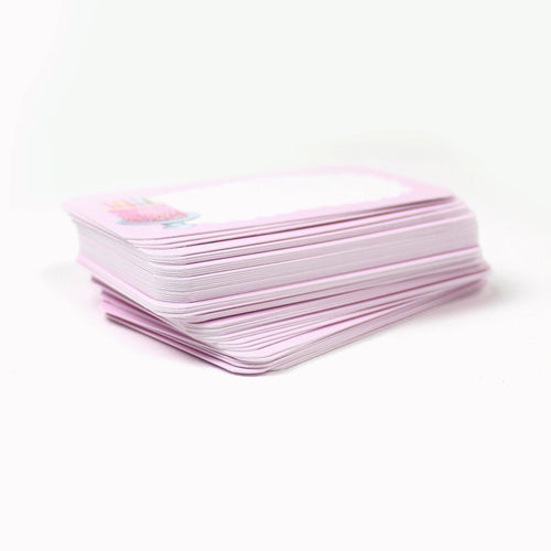 Stack of light pink pocket cards with a birthday cake illustration on a white background