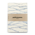 Notebook with wavy pattern and 'petit gramme' branding on a white background
