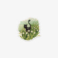 Sticker of a black cat in a field of flowers on a white background