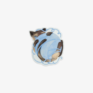 Vinyl sticker of a cat wrapped in blue yarn on a light blue background