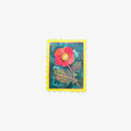 A rectangular postage stamp-style art print with a scalloped yellow border, featuring a red flower and green leaves on a textured teal background, centered on a light gray backdrop.