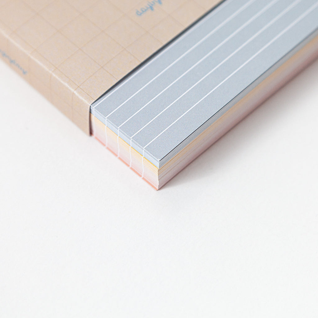 Close-up of a memo card with lined pages on a light background