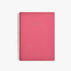 Pink notebook with spiral binding on a white background