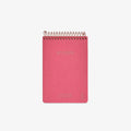 Pink notebook with gold spiral binding on a white background
