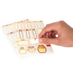 Hand holding a sheet of decorative labels with animal designs on a white background