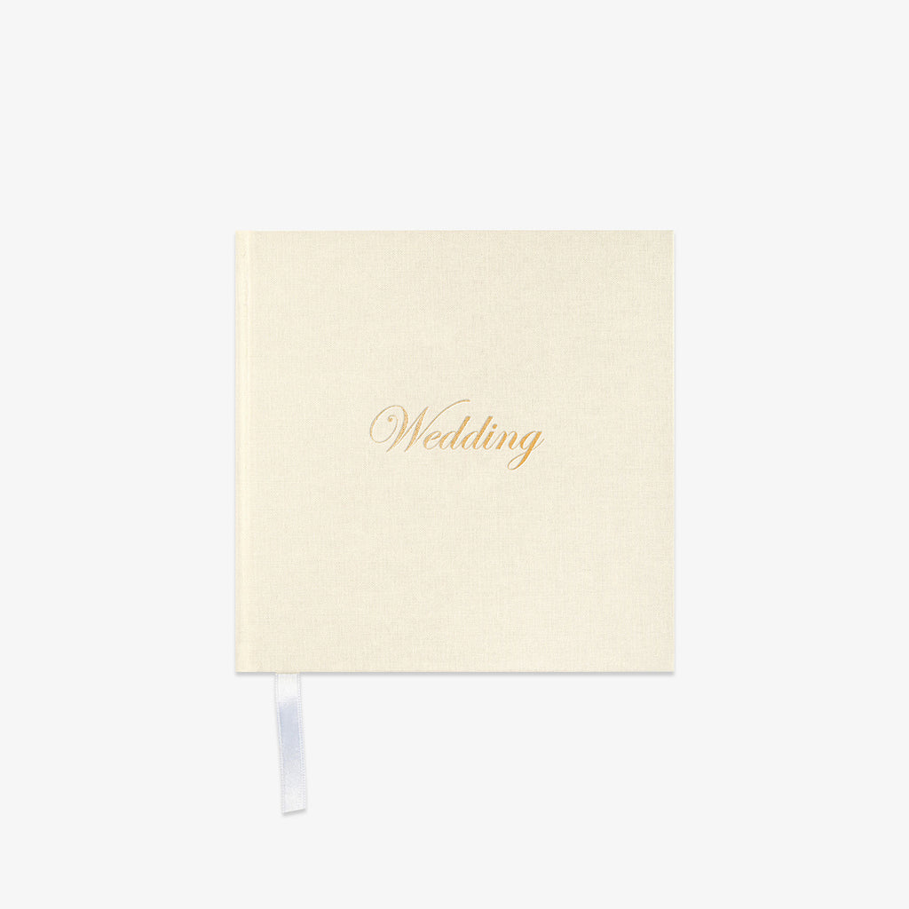 Cream-colored notebook with 'Wedding' in gold text o