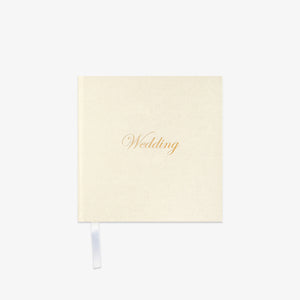 Cream-colored notebook with 'Wedding' in gold text o