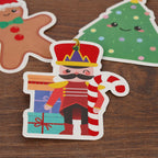 Christmas-themed gift tags including a nutcracker, gingerbread man, and tree on a wooden surface.