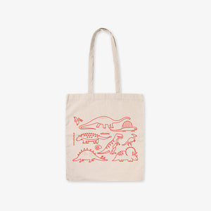 Beige tote bag with red dinosaur illustrations on a white background