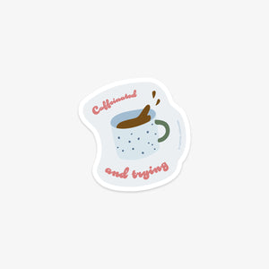 Vinyl sticker with a coffee cup design and text 'Caffeinated and trying' on a white background