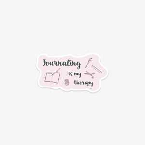 Venyl sticker with 'Journaling is my therapy' text and journal, pen, and jar illustrations on a pink background.