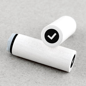Two white rubber stamps with check symbols on a beige background