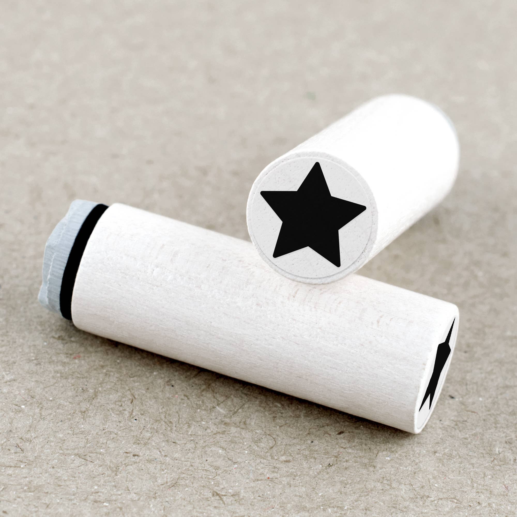 Two wooden rubber stamps with black star designs on a beige background