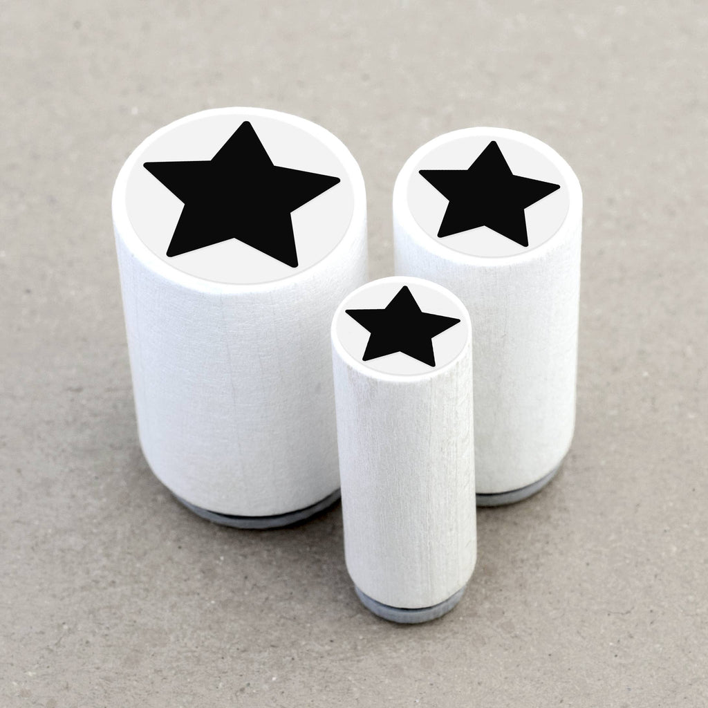 Three wooden rubber stamps with black star designs on a gray background