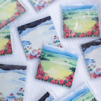 Sticky notes with scenic and floral designs on a white surface