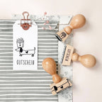 Wooden stamps with printed designs on a striped paper and white background