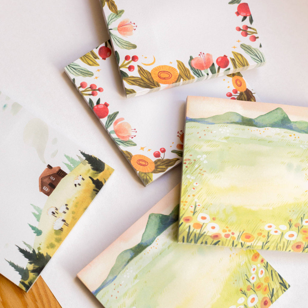 Set of sticky notes with nature-themed illustrations on a white surface.