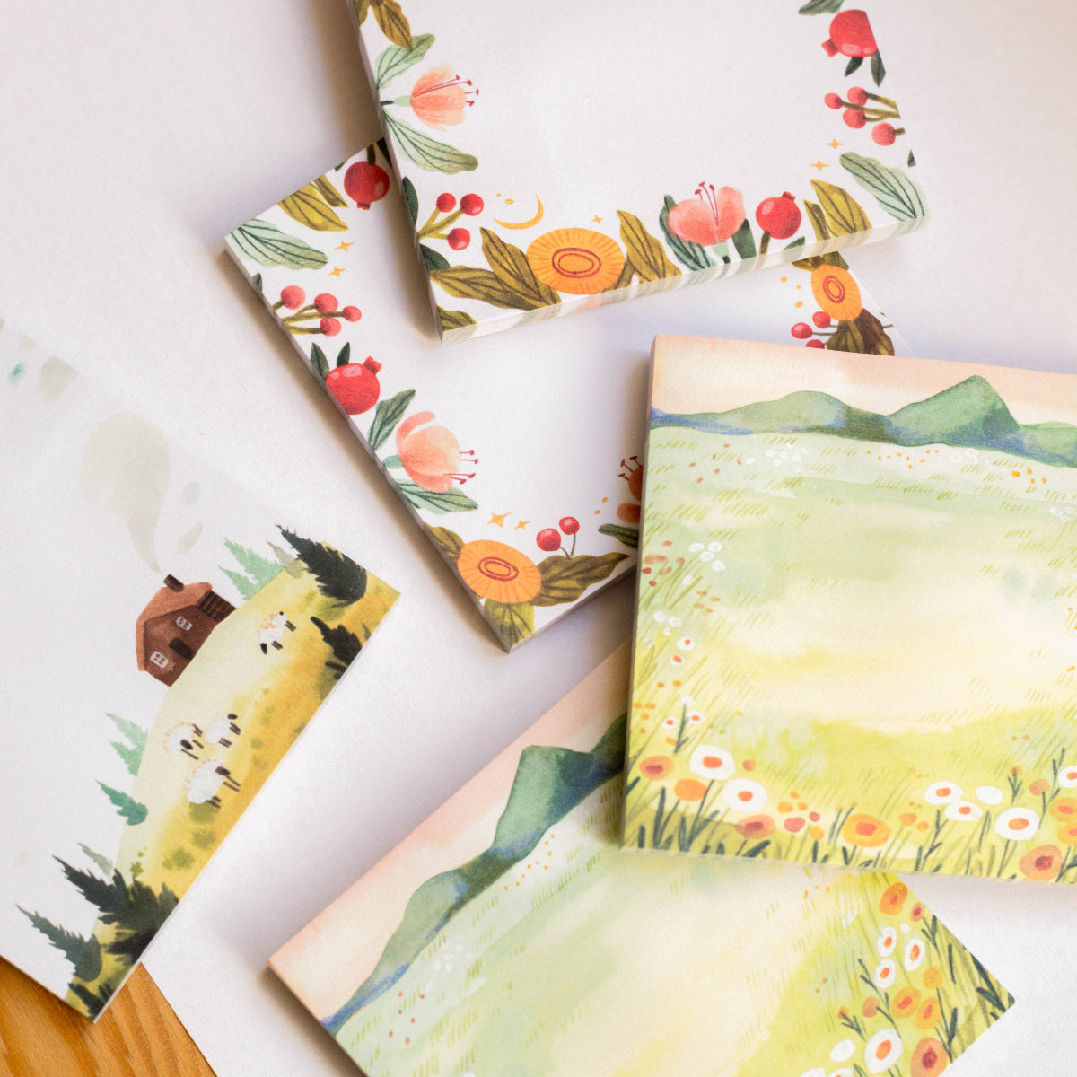 Set of sticky notes with nature-themed illustrations on a white surface.