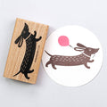 Wooden stamp with a dachshund design and a matching printed design on paper.