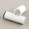 Two white rubber stamps with flame symbols on a beige background
