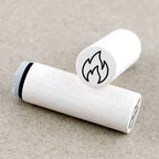 Two white rubber stamps with flame symbols on a beige background