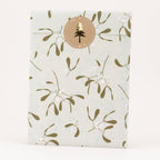 Packaging with a gold mistletoe pattern and a circular logo on a white background