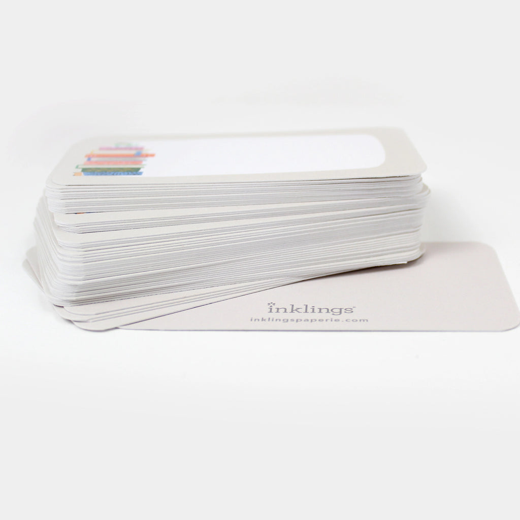 Stack of white cards with a book stack illustration and 'inklings' branding on a white background