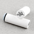 Two white rubber stamps with plant symbols on a beige background