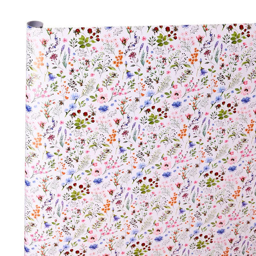 A roll of wrapping paper or fabric with a dense, multicolor floral and botanical pattern on a white background, shown against a plain white backdrop.