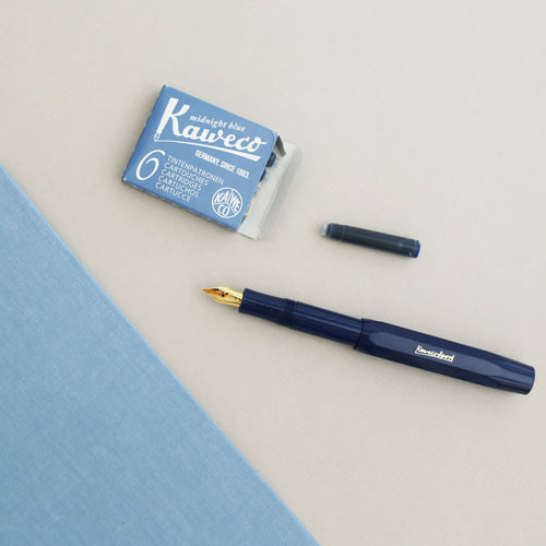 A navy Kaweco Classic Sport fountain pen with a gold nib and midtnight blue ink.